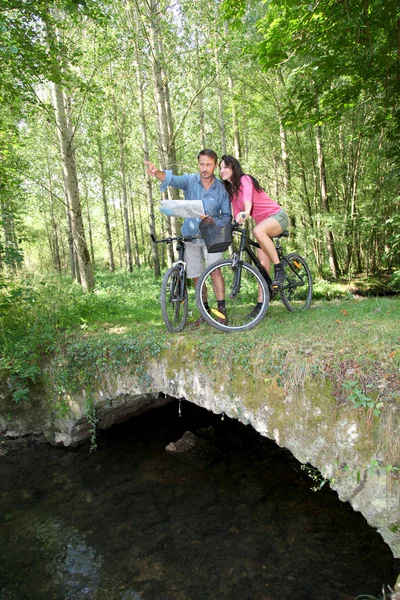 Couple riding bike in countryside — Stock Photo, Image