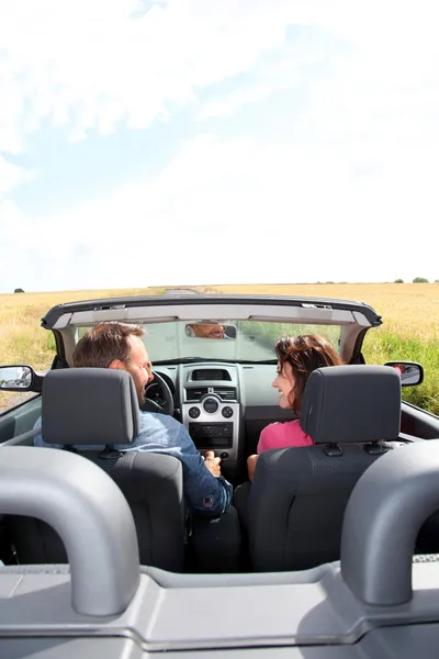 Casal equitação conversível carro — Fotografia de Stock