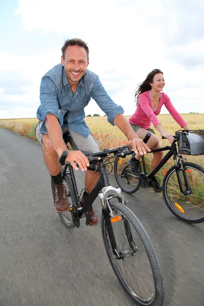 Casal andar de bicicleta na estrada de campo — Fotografia de Stock