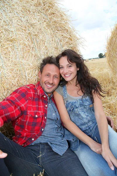 Couple relaxing in hay bales — Stock Photo, Image