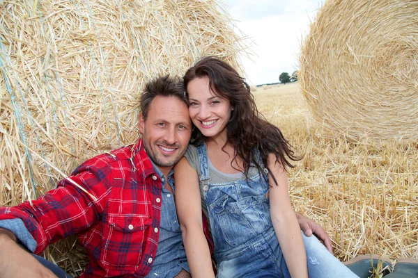 Couple relaxing in hay bales — Stock Photo, Image