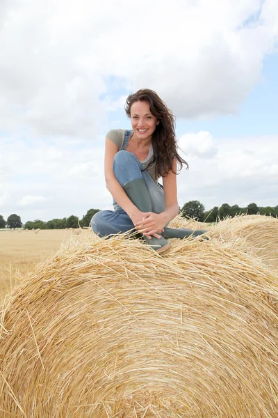 Woman having fun sitting on hay bale — Stock Photo, Image