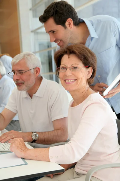 Portrait of senior woman attending computing training — Stock Photo, Image