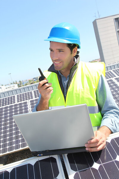 Engineer with walkie-talkie on photovoltaic installation