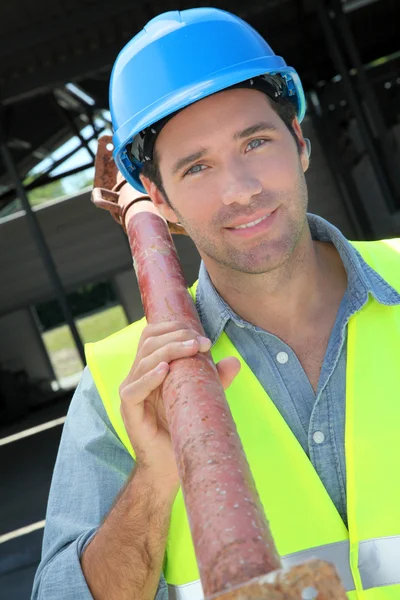 Worker lifting prop on construction site — Stock Photo, Image