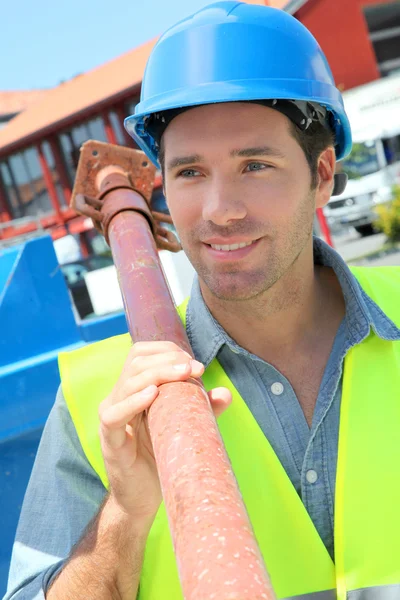 Worker lifting prop on construction site — Stock Photo, Image