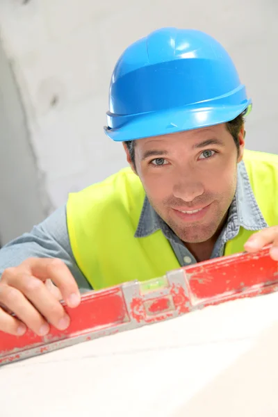 Trabalhador usando nível no local de construção — Fotografia de Stock