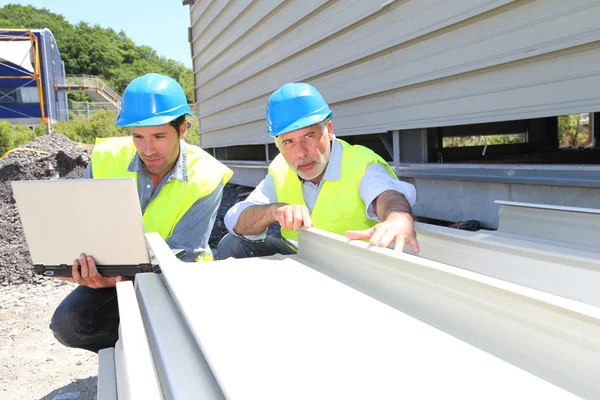 Construction workers checking building material — Stock Photo, Image