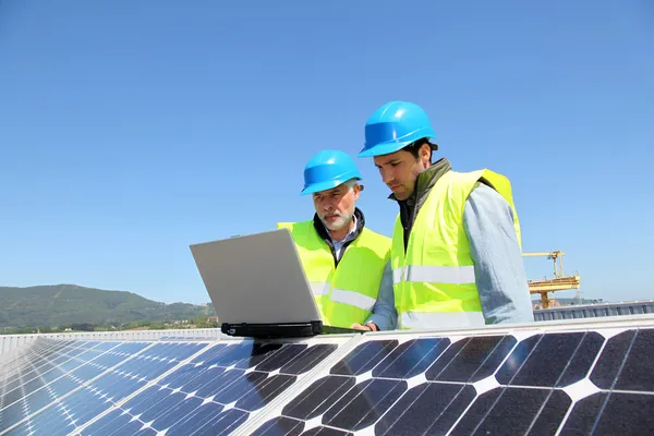 Ingenieros comprobando la configuración del panel solar — Foto de Stock