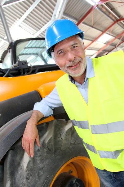 Site manager standing by machine — Stock Photo, Image