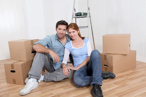 Jovem casal sentado em sua nova casa — Fotografia de Stock