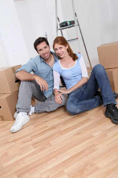 Jovem casal sentado em sua nova casa — Fotografia de Stock