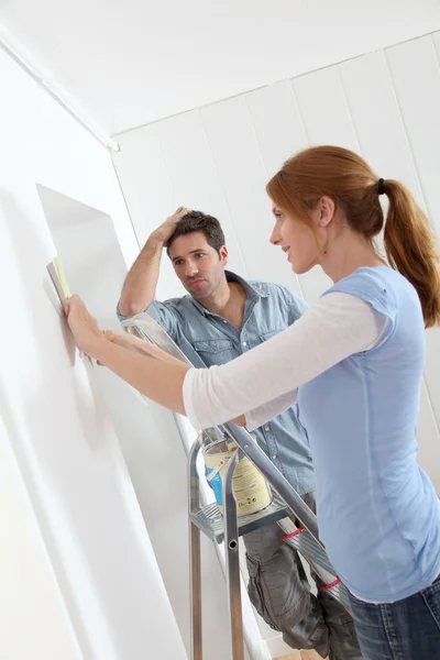 Pareja elegir el color de fondo de pantalla para la nueva casa — Foto de Stock