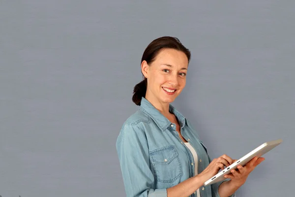 Smiling woman using electronic tablet Stock Photo