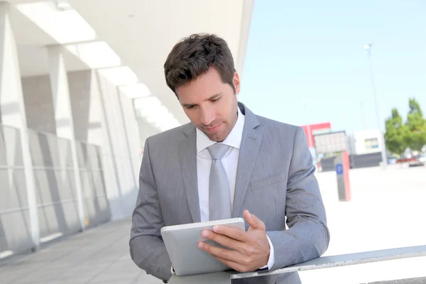 Businessman using electronic tablet outside a building Stock Photo