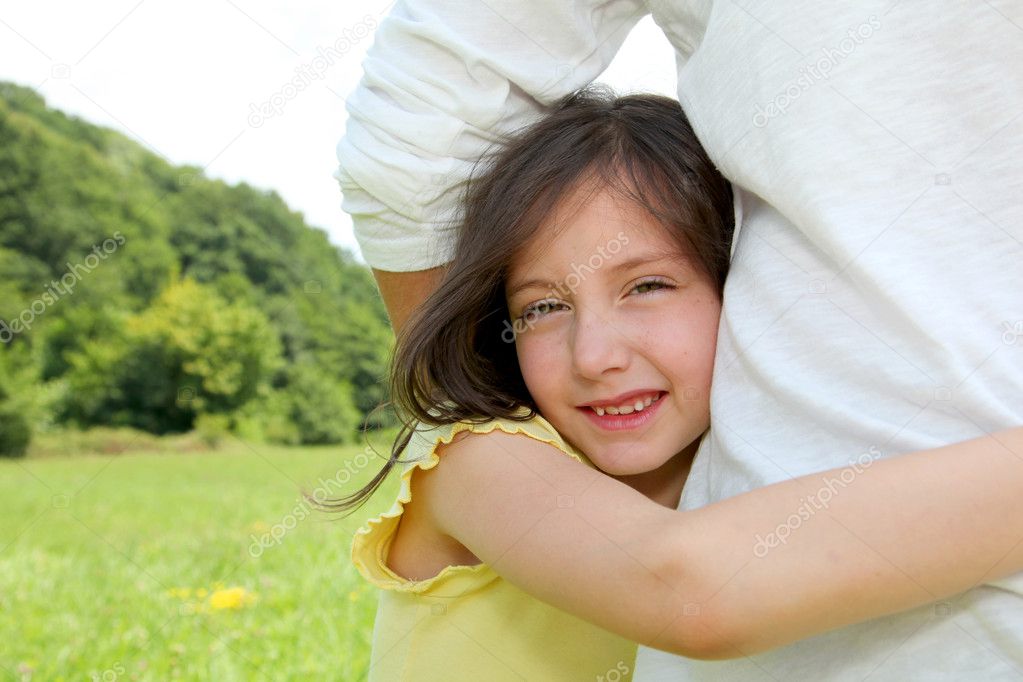 Little girl putting her arms around her father waist Stock Photo by ©Goodluz 18210865