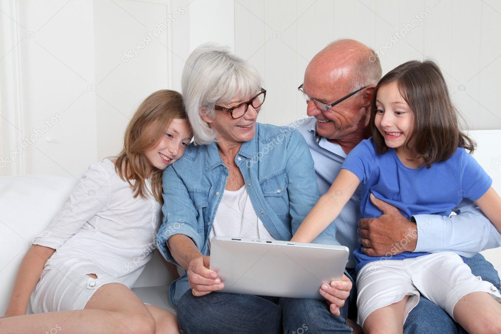 Senior with grandkids using electronic tablet