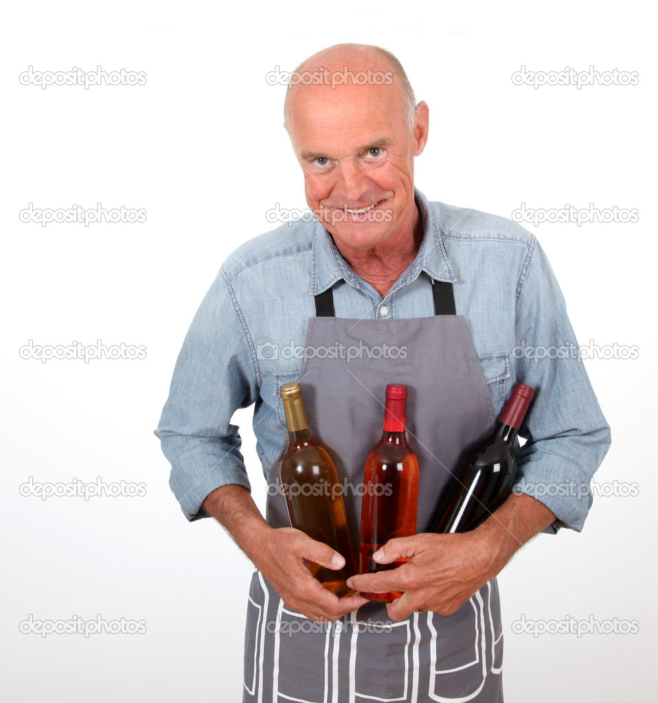 Portrait of senior winemaker holding bottles of wine