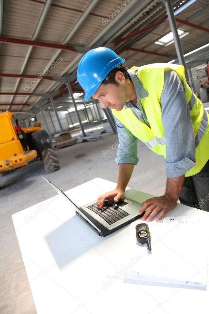 Engineer using laptop computer on construction site