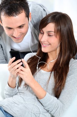 genç bir çift cep telefonu ile müzik dinlemek