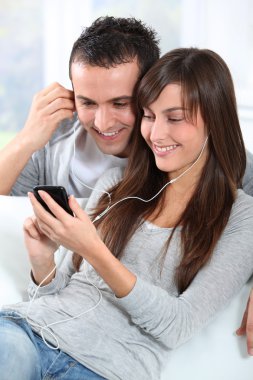 genç bir çift cep telefonu ile müzik dinlemek