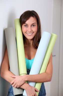 rulo duvar kağıdı tutan güzel genç kadın