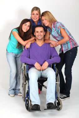 Young man in wheelchair with group of girl friends