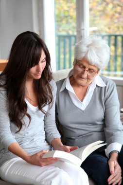 genç kadın yaşlı kadın için kitap okumak