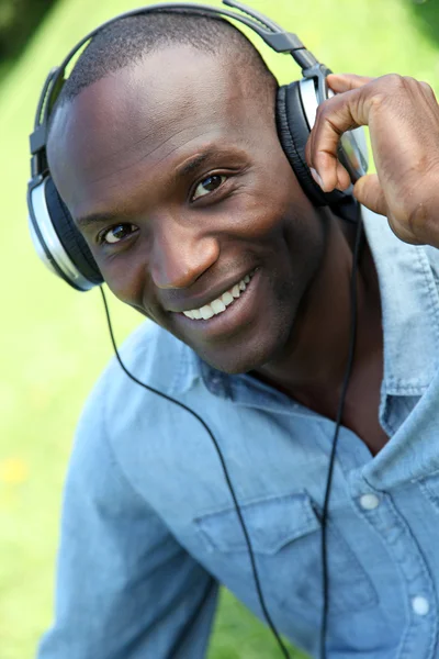 Man relaxing in garden with headphones on — Stock Photo, Image