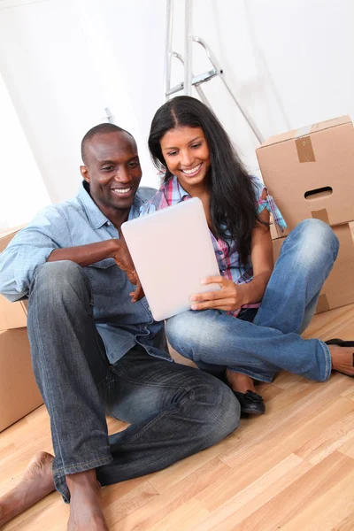 Couple using electronic tablet in their new house