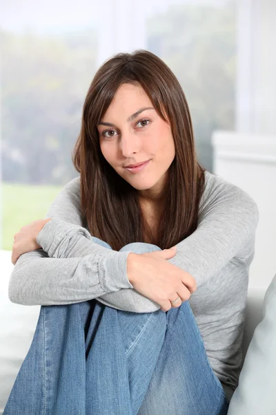 Mooie vrouw zittend op de bank thuis — Stockfoto