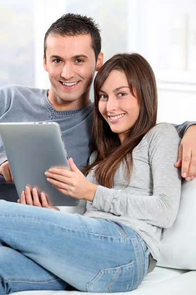 Pár sedí na pohovce s elektronickým pad — Stock fotografie