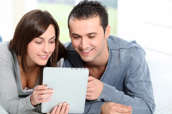 Paar sitzt auf Sofa mit elektronischem Pad — Stockfoto