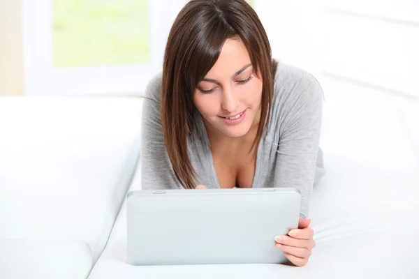 Young woman laying on sofa with electronic pad — Stock Photo, Image