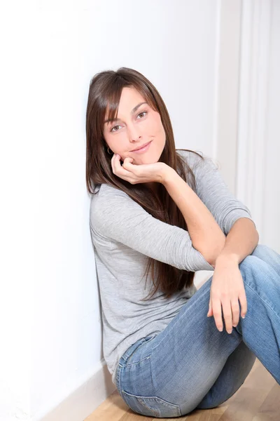 Красивая молодая женщина сидит на полу — стоковое фото