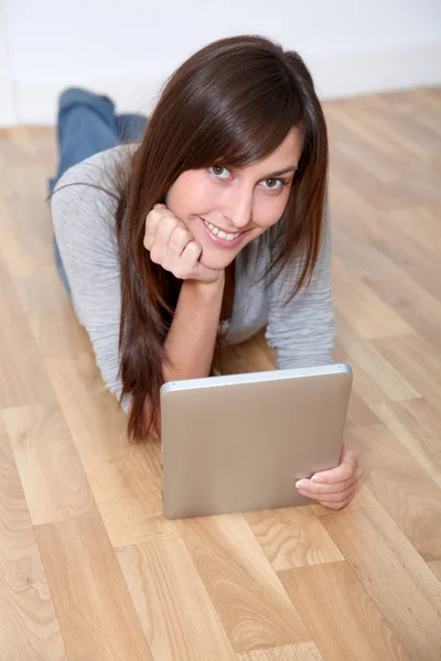 Young woman laying down the floor with electronic pad — Stock Photo, Image