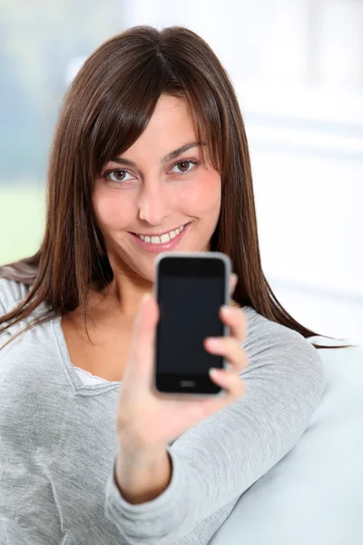Schöne junge Frau zeigt Handy — Stockfoto