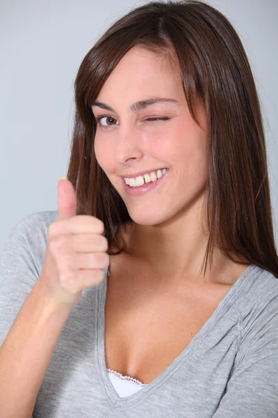 Closeup of ywinking woman with thumb up — Stock Photo, Image