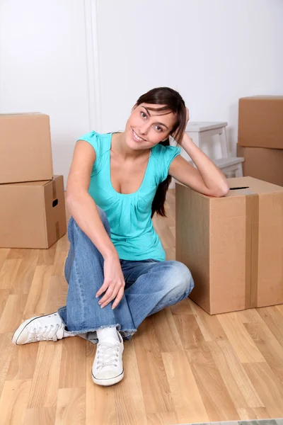 Mooie jonge vrouw zitten naast vakken in nieuwe huis — Stockfoto