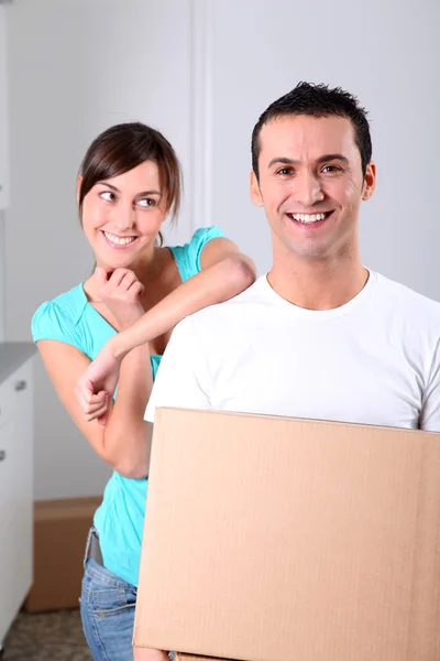 Casal jovem carregando caixas em casa nova — Fotografia de Stock