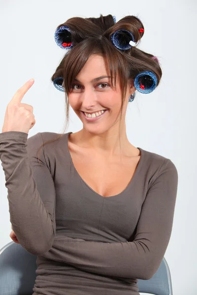 Mulher bonita com encrespadores de cabelo fazendo caras engraçadas — Fotografia de Stock