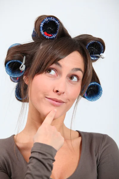 Mulher bonita com encrespadores de cabelo fazendo caras engraçadas — Fotografia de Stock