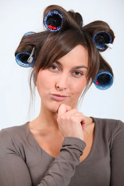 Mulher bonita com encrespadores de cabelo fazendo caras engraçadas — Fotografia de Stock