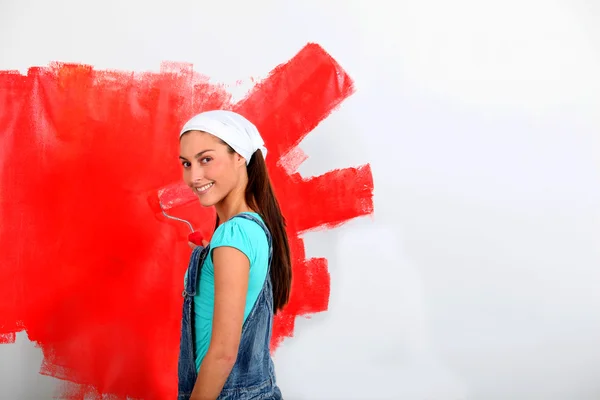 Junge Frau streicht Hauswand in Rot — Stockfoto