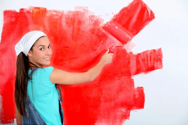 年轻女子绘画的房子墙体红色 — 图库照片