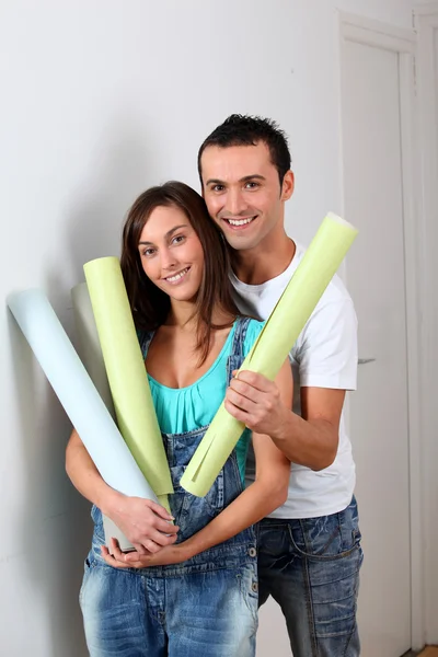 Fechar-se de jovem casal segurando rolos de papel de parede — Fotografia de Stock