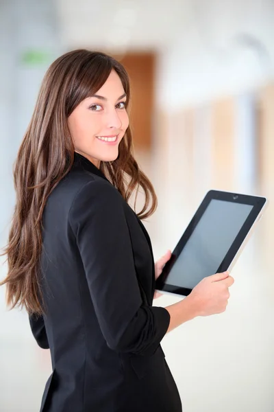 Businesswoman standing in hall with electronic pad — Stock Photo, Image