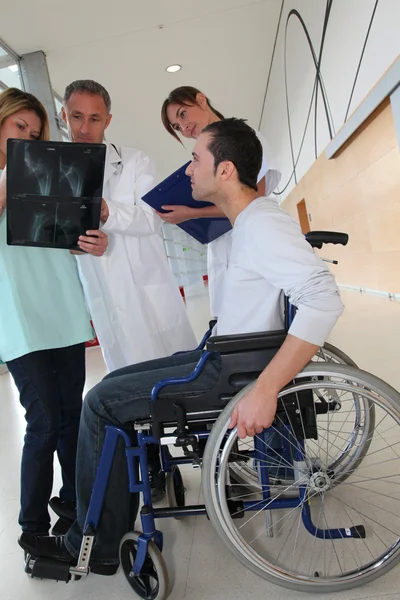 Equipe médica com deficiente olhando para raio-X — Fotografia de Stock