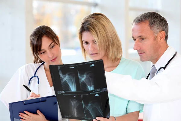 Lékařský tým s postiženou osobu při pohledu na x-ray — Stock fotografie
