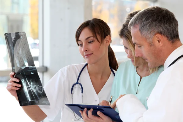 Lékařský tým s postiženou osobu při pohledu na x-ray — Stock fotografie